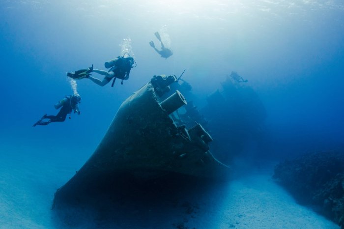 Scuba divers explore a wrecked ship